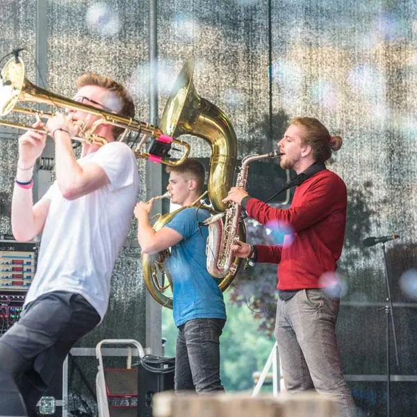 Bläser von Duke Brass spielen bei einem Festivalauftritt im Freien
